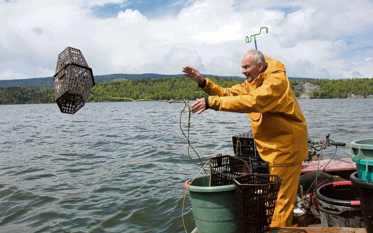 Der Berufsfischer Jean-Daniel Meylan wirft eine Reuse zum Fang von Signalkrebsen im Lac de Joux aus. 