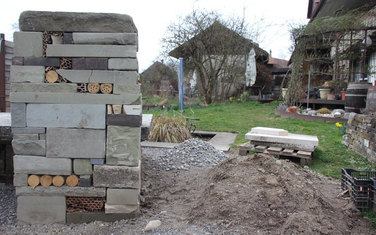 Eine Baustelle eines Landschaftsgärtners. Am Entstehen sind ein Insektenhotel und eine Teichlandschaft. 